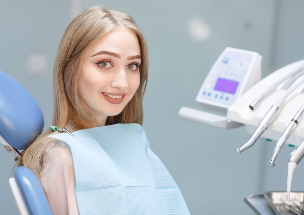 female patient sitting comfortably in dental chair during TMJ treatment consultation in modern dental clinic