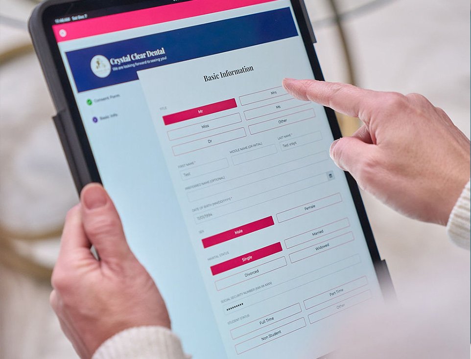 Patient filling out digital forms on a tablet at Crystal Clear Dental, enhancing the check-in experience with crystal clear family dentist in San Antonio.