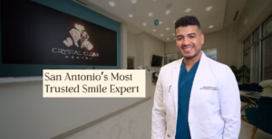 Smiling dental professional in white coat standing in Crystal Clear Dental clinic, promoting trusted smile care in San Antonio