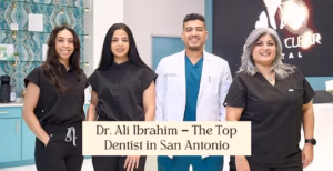 Dr. Ali Ibrahim with team at Crystal Clear Dental clinic in San Antonio, smiling in front of teal reception area.