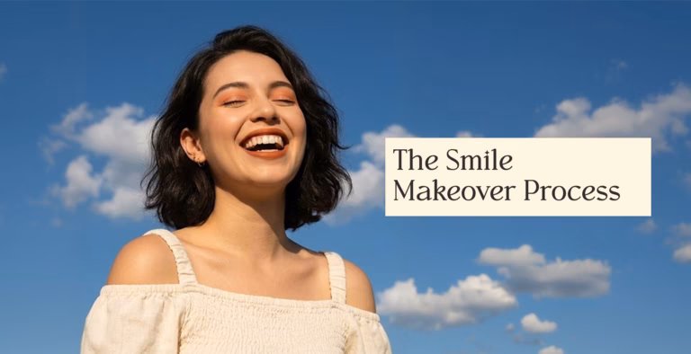 hair laughs with closed eyes against a blue sky with soft white clouds.