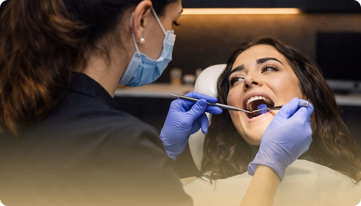 Dentist examining patient's teeth with dental instruments during an implant consultation